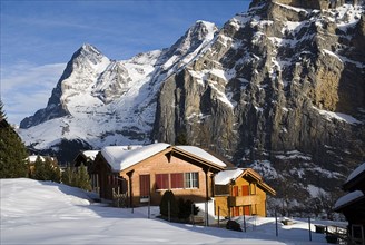SWITZERLAND, Bernese Oberland, Murren, Snow covered houses in Murren with Eiger Mountain behind