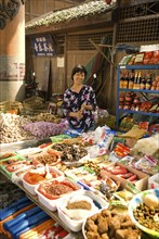 CHINA, Sichuan Province, Chongqing, "Street market with a smiling woman vendor selling spices,