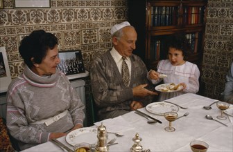 ENGLAND, Religion, Judaism, "Jewish New Year meal, young girl passing the chala or bread to family