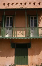 SENEGAL, Goree Island, "Detail of house with a green balcony, shutters and door"