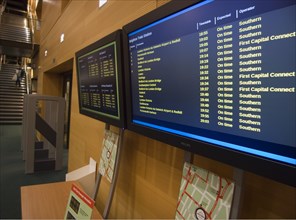 ENGLAND, East Sussex, Brighton, Display of live train and bus times in public library.