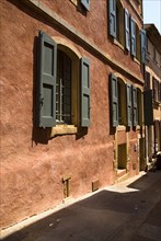 FRANCE, Provence Cote d’Azur, Vaucluse, Roussillon.  Typical red exterior wall of building with
