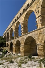 FRANCE, Provence Cote d’Azur, Gard, Pont du Gard.  Angled view of three tiers of arches of Roman