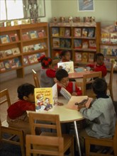 KUWAIT, Education, Kindergarten class with children sitting around tables reading books