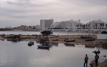 TUNISIA, Monastir, Hotels viewed from marina across beach and harbour.