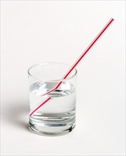 SCIENCE, Optics, Refraction, "A red and white straw in a glass of water on a white background. The
