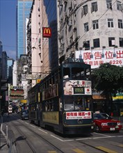 CHINA, Hong Kong, Hong kong Island tram on busy city street with high rise buildings and