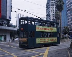 CHINA, Hong Kong, Hong kong Island tram with advertising printed along side and high rise buildings
