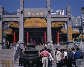 CHINA, Hong Kong, Kowloon, Wong Tai Sin taoist temple established in 1921.  Visitors beside incense