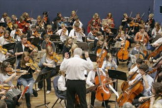 CHILDREN, Education, Music, Youth orchestra with conductor in foreground. Sir Michael Tippet giving