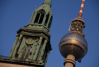 GERMANY, Berlin, Angled detail of the Fernsehturm or television tower beside clock and bell tower