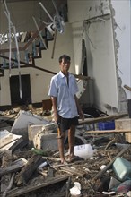 THAILAND, Phang Nga District, Nam Khem, "Tsunami. A man stands outside of what is left of his house