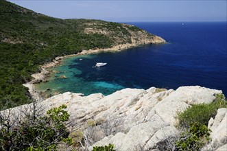 FRANCE, Corsica, Calvi, "Rocky coastline & deep blue waters with boat, coastline near Calvi"