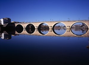 FRANCE, Dordogne, Perigeux, Bergerac. Old bridge over River Dordogne with its reflection on the