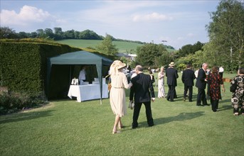 ENGLAND, East Sussex, Glyndebourne, Opera attendees enjoying picnics in the gardens during Opera