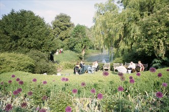 ENGLAND, East Sussex, Glyndebourne, Opera attendees enjoying picnics in the gardens during interval