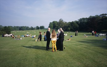 ENGLAND,  East Sussex, Glyndebourne, Opera attendees enjoying picnics in the gardens during