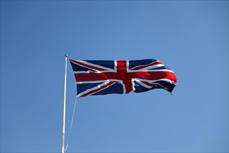 CLIMATE, Wind, Flags, British Union Jack flag flying in wind against blue sky.