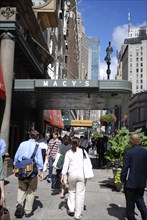 USA, New York, Manhattan, Broadway with people walking along the sidewalk outside the entrance to