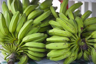 WEST INDIES, Grenada, Carriacou, Hillsborough Bundles of green bananas on a stall in the main