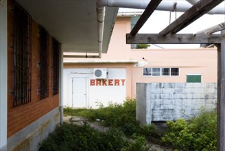 WEST INDIES, St Vincent & The Grenadines, Union Island, Derelict bakery set amongst waste ground in