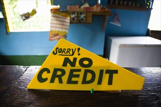 WEST INDIES, Grenada, St Georges, Sign on the counter of a shop that says Sorry No Credit.
