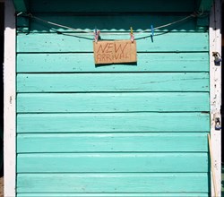 WEST INDIES, Grenada, Carriacou, New Arrival sign on the padlocked turqoise shutter of a shop in
