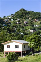 WEST INDIES, Grenada, St George, Houses built on stilts lining a hillside.