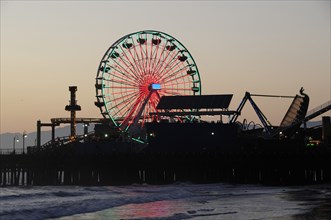 USA, California, Los Angeles, Santa Monica pier Silhouetted at dusk. Ferris wheel funfair