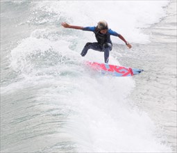 USA, California, Los Angeles, Riding the surf at Huntington Beach
