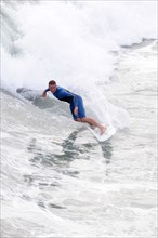 USA, California, Los Angeles, Riding the surf at Huntington Beach