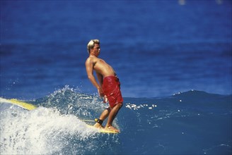 SPORT, Sea, Surfing, "Surfer hangs ten.  Male surfer walks to the point of the board and hangs ten
