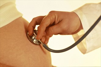MEDICAL, Health, Pregnancy, Cropped view of doctor using stethoscope to examine pregnant woman.