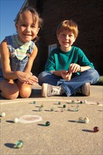 CHILDREN, Play, Young boy and girl playing game of marbles.