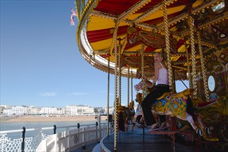 ENGLAND, East Sussex, Brighton, The Pier with a happy laughing young girl on a traditional