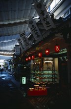 Japan, Honshu, Miyajima, Restaurant with window display and red paper lanterns in street with