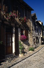 France, Aquitaine, Bergerac, Row or terrace of stone houses with wooden window shutters and hanging