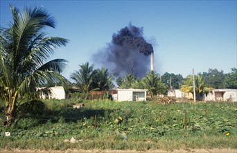 Cuba, Varadero, Sugar cane factory emitting clouds of black smoke from chimneys.