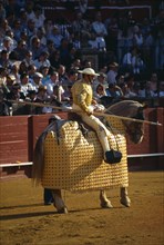 Spain, Andalucia, Seville, Picador with lance riding a padded and blindfolded horse in the bullring