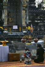 Thailand, North, Chiang Mai, Wat Chettawan Buddhist temple on Tha Phae Road with woman and young