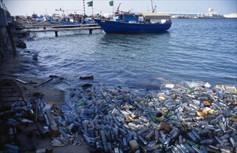 Libya, Tripolitania, Tripoli, Plastic water bottles and other rubbish polluting harbour.