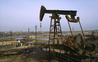 Azerbijan, Polluted wasteland with nodding donkey of oil field near Baku.