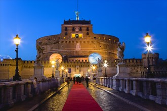 ITALY, Rome, Lazio, The fortress of Castel Sant Angelo illuminated at night with a red carpet laid
