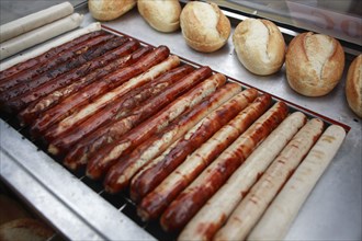 Germany, Berlin, Frankfurter sausages are grilled at snack stand.