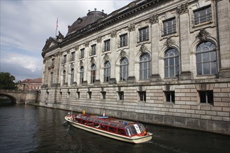 Germany, Berlin, Tourist ferry on Spree Canal passing the Bode Museum.