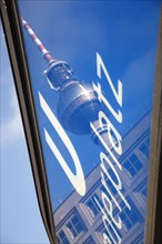 Germany, Berlin, U Bahn sign for Alexanderplatz with Fernsehturm reflected  in the glass.