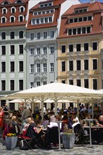 GERMANY, Saxony, Dresden, People sitting at restaurant cafe tables under umbrellas in Neumarkt