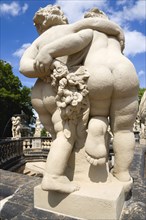 GERMANY, Saxony, Dresden, Statue seen from behind of two fat naked figures walking with their arms