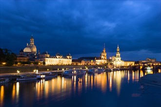 GERMANY, Saxony, Dresden, The city skyline at night with cruise boats moored on the River Elbe in