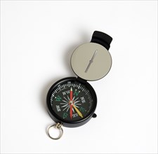 Travel, Navigation, Map Reading, Sighting compass with dial pointing to magnetic north on a white